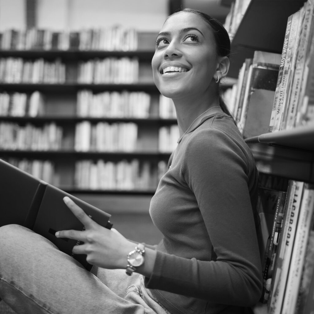 Student smiling with book in hand