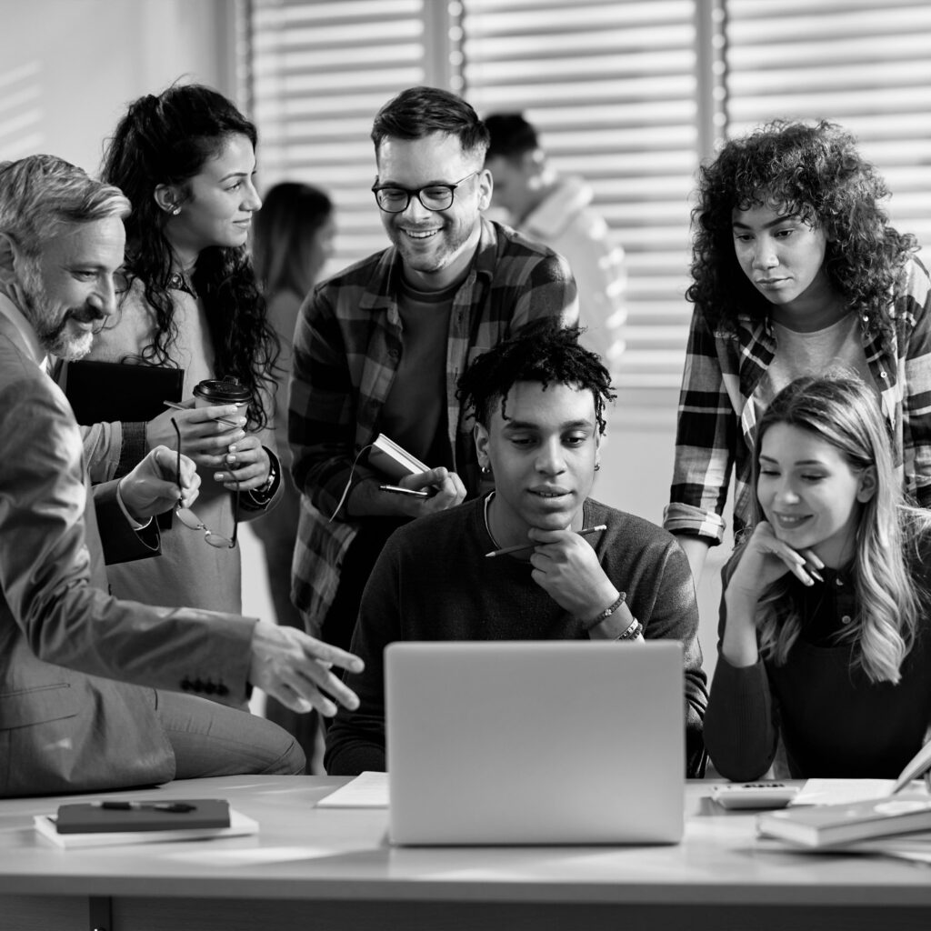 Group of students huddled around a laptop